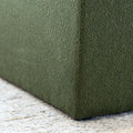 Détail ottoman carré vert en tissu texturé, finition soignée et angle net pour salon moderne.