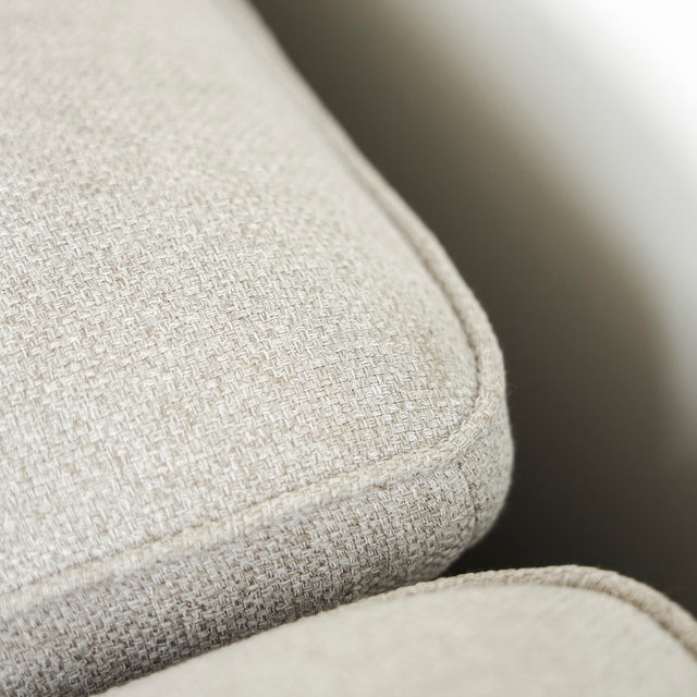 Image rapprochée d'un Sectionnel en tissu greige avec pattes noires, design moderne et assises confortables pour salon contemporain.