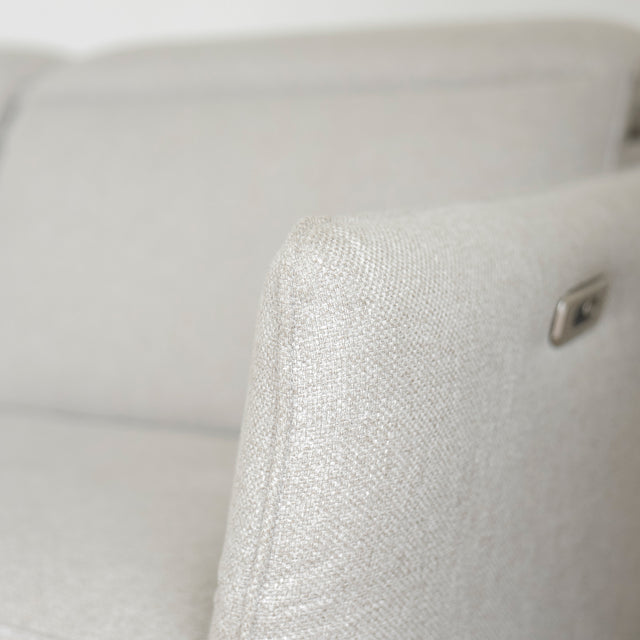 Image rapprochée d'un Sectionnel en tissu greige avec pattes noires, design moderne et assises confortables pour salon contemporain.