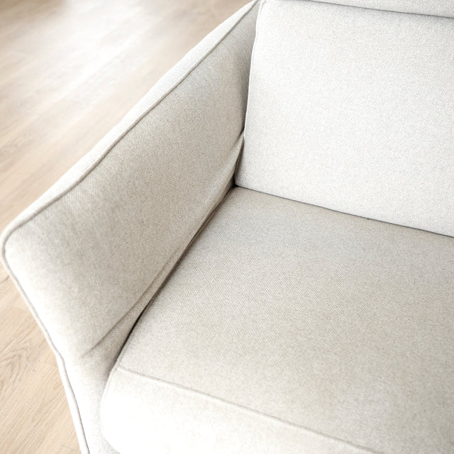 Image rapprochée d'un Sectionnel en tissu greige avec pattes noires, design moderne et assises confortables pour salon contemporain.