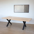 Table rectangulaire en bois clair avec pieds en metal noir en X, design industriel elegant avec cercles indiquant les défauts.