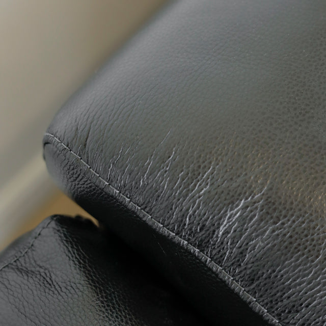 gros plan sur le cuir noir du canape montrant la texture naturelle et les coutures fines.
