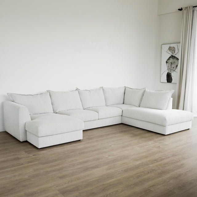 grand canape d angle gris clair moderne sur parquet bois dans salon epure.
