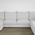canape gris clair avec grands coussins d assise et de dossier sur sol en bois.
