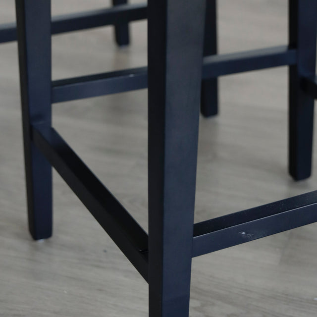 image rapprochée des pattes en bois noir comportant un léger défaut sur l'appuie pied