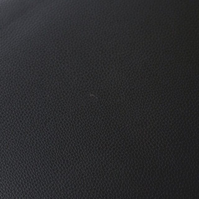 image rapprochée d'un ensemble de chaises moderne en simili cuir noir avec dossier a coutures horizontales et pieds en metal. Comportant une tache