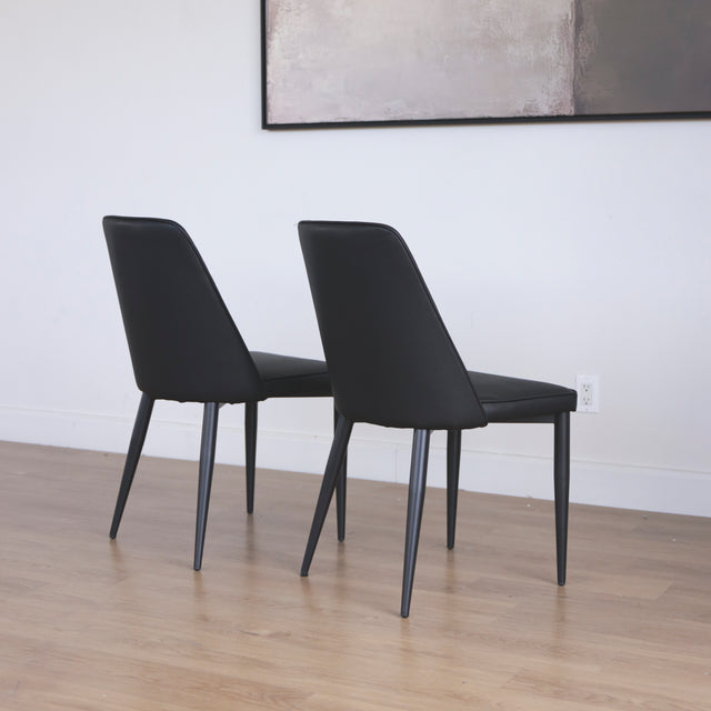 ensemble de chaises moderne en simili cuir noir avec dossier a coutures horizontales et pieds en metal.