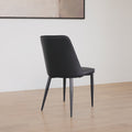 dos d'une chaise moderne en simili cuir noir avec dossier a coutures horizontales et pieds en metal.