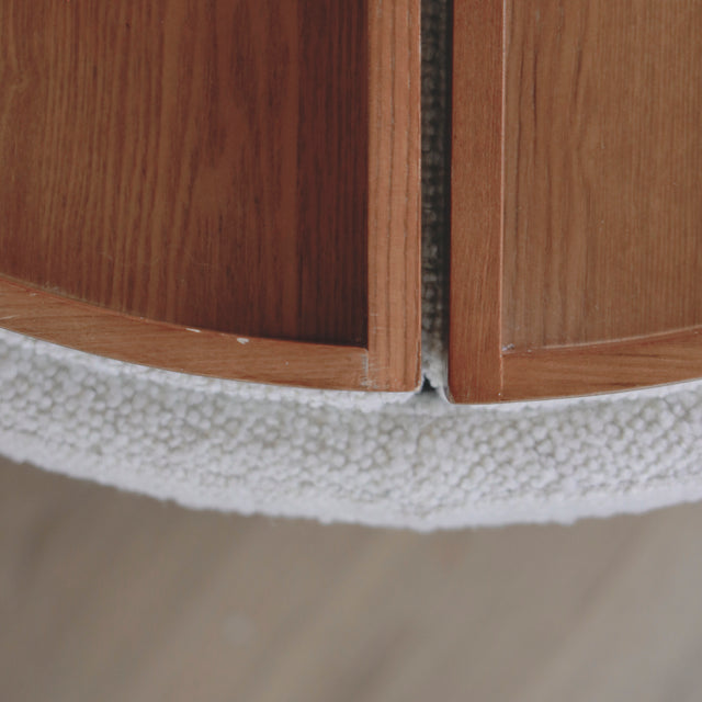 image rapprochée d'un ottoman en tissu blanc bouclé avec plateau amovible en bois noyer.