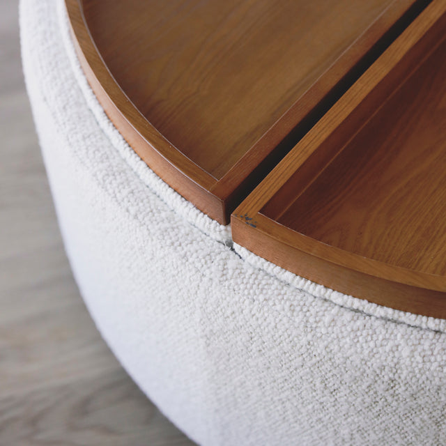 image rapprochée d'un ottoman en tissu blanc bouclé avec plateau amovible en bois noyer.
