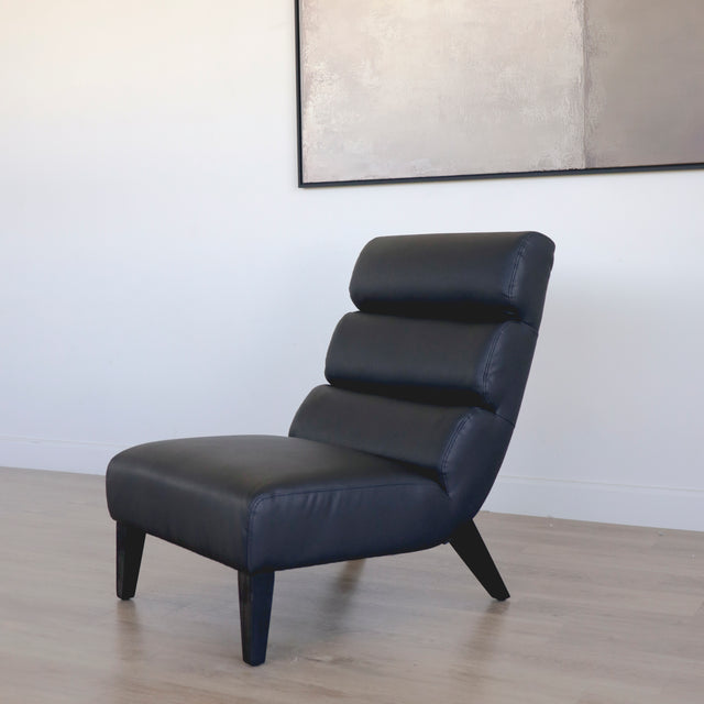 Fauteuil moderne en cuir noir avec dossier capitonne et pieds en bois fonce.