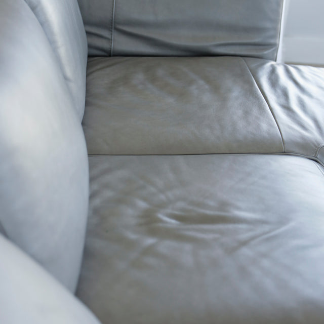 Image rapprochée d'un Canape avec chaise longue droite en cuir gris clair avec pieds noirs.