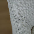image rapprochée d'un ensemble de chaises modernes en tissu bouclé ivoire avec pieds en bois pâle avec défaut d'une tache.