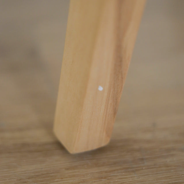 image rapprochée d'un ensemble de chaises modernes en tissu bouclé ivoire avec pieds en bois pâle avec défaut d'un accroc sur une patte.