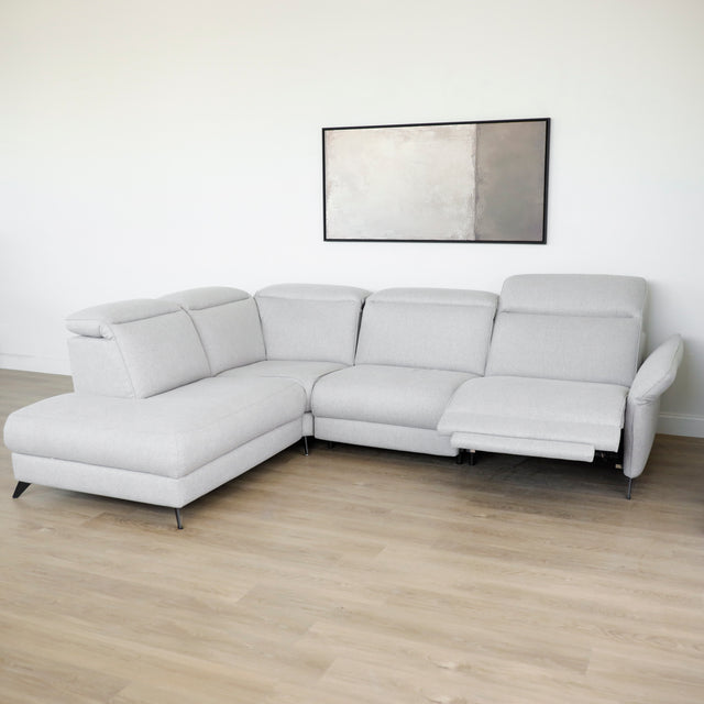 Modulaire inclinable moderne en tissu gris clair avec pieds metalliques noirs sur parquet clair.