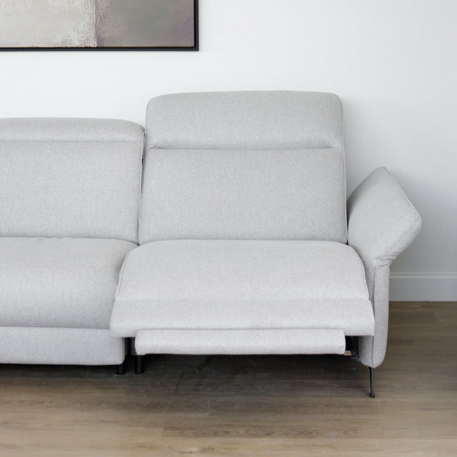 Modulaire inclinable moderne en tissu gris clair avec pieds metalliques noirs sur parquet clair.