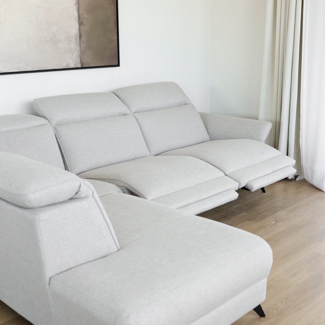 Modulaire inclinable moderne en tissu gris clair avec pieds metalliques noirs sur parquet clair.