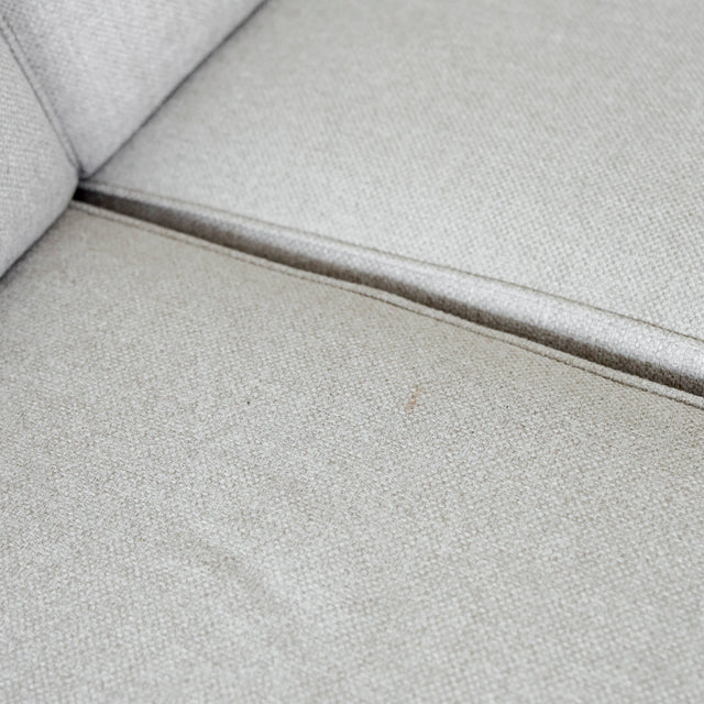 Modulaire inclinable moderne en tissu gris clair avec pieds metalliques noirs sur parquet clair.