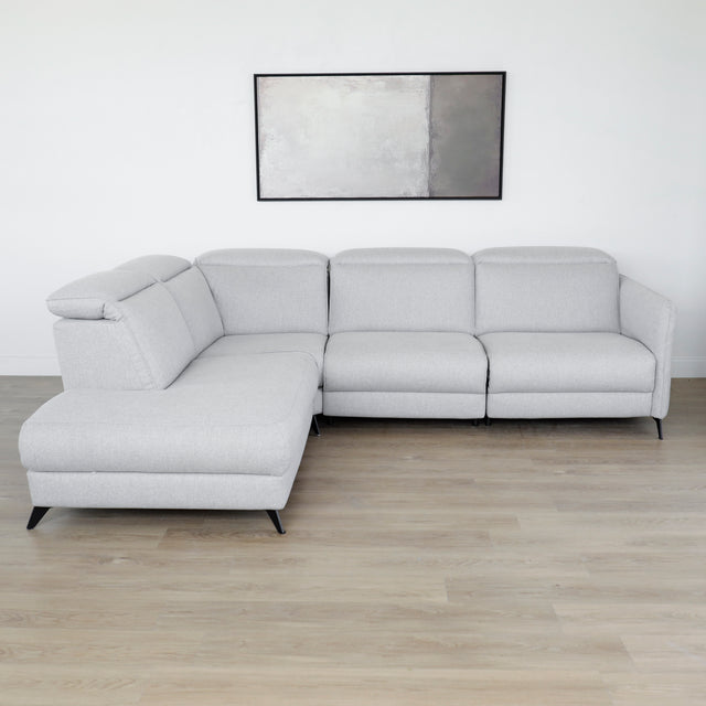 Modulaire inclinable moderne en tissu gris clair avec pieds metalliques noirs sur parquet clair.