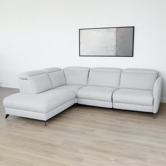 Modulaire inclinable moderne en tissu gris clair avec pieds metalliques noirs sur parquet clair.