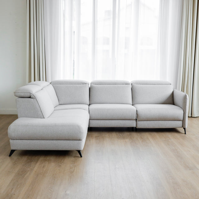 Modulaire inclinable moderne en tissu gris clair avec pieds metalliques noirs sur parquet clair.