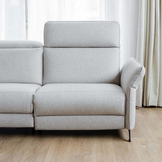 Modulaire inclinable moderne en tissu gris clair avec pieds metalliques noirs sur parquet clair.