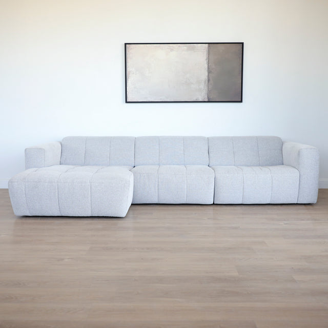 Modulaire d'angle moderne avc chaise longue gauche en tissu gris clair.