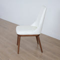 chaise blanche elegante avec assise rembourree et pieds en bois.