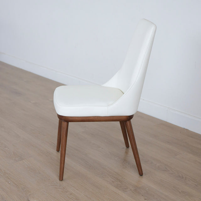 chaise blanche elegante avec assise rembourree et pieds en bois.