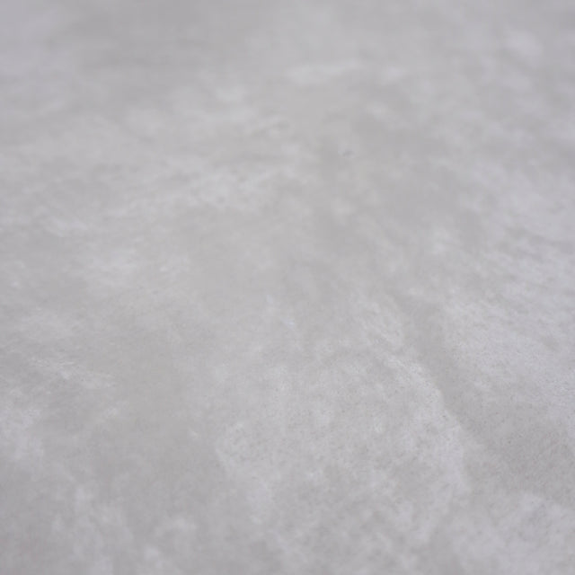 Image rapprochée table rectangulaire en beton avec pieds en metal noir en X, style industriel moderne.