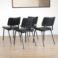 Quatre chaises noires en simili cuir avec pieds en metal, design moderne pour salle a manger.