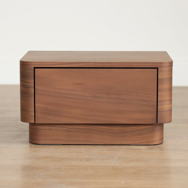 Table de chevet moderne en bois noyer avec coins arrondis et tiroir integre.