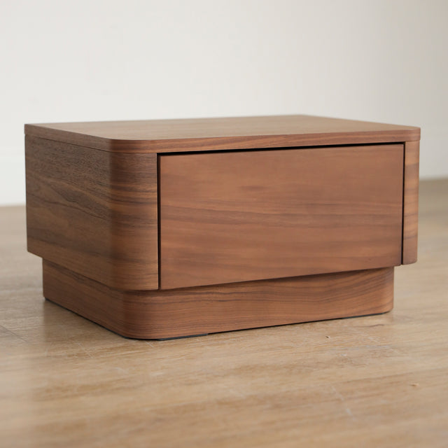 Table de chevet moderne en bois noyer avec coins arrondis et tiroir integre.