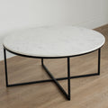 Table basse ronde avec plateau en marbre blanc et structure en metal noir, style moderne et minimaliste.