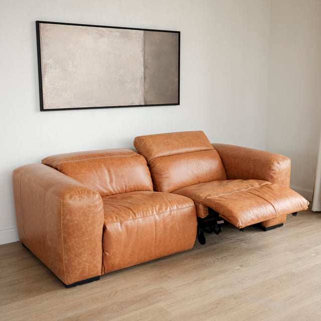Canape inclinable en cuir brandy au design contemporain avec accoudoirs larges et assises confortables.