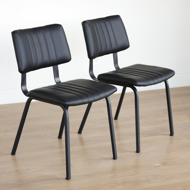 Deux chaises noires en simili cuir avec structure en metal, design industriel moderne.