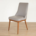 Chaise moderne en cuir gris avec assise rembourree et pieds en bois.