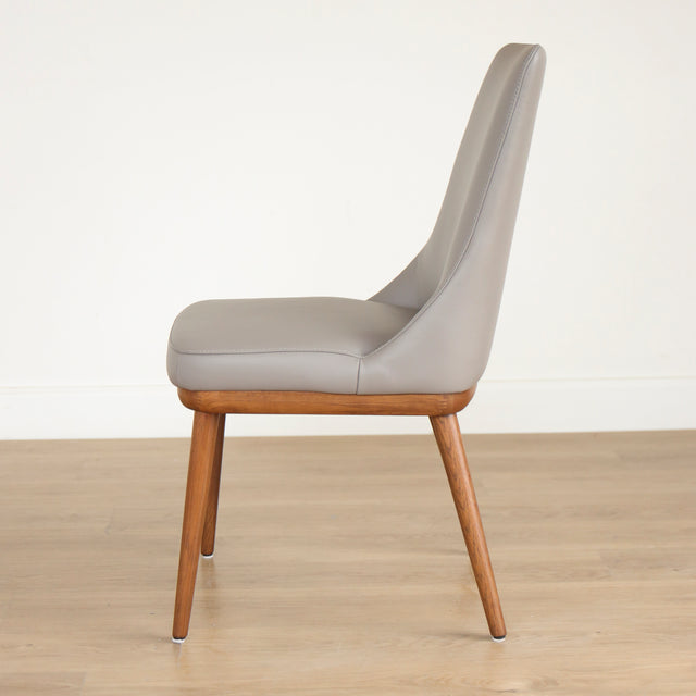 Chaise moderne en cuir gris avec assise rembourree et pieds en bois.