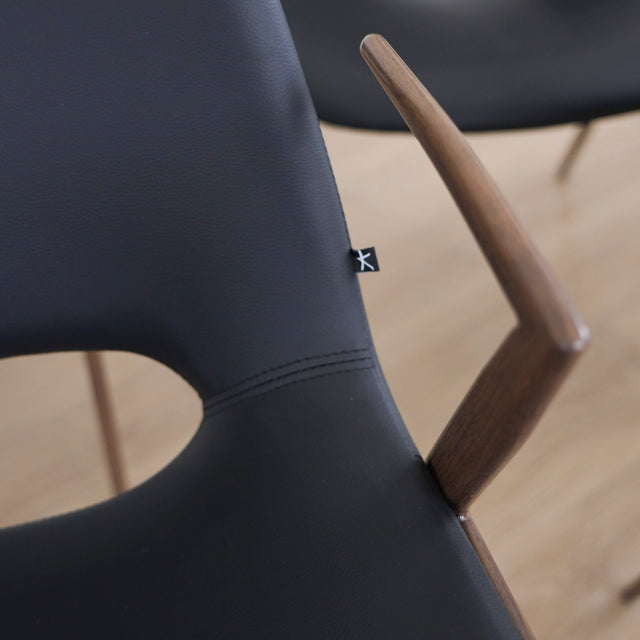 ensemble de chaises noires modernes avec accoudoirs en métal imitation bois et assise ajouree.