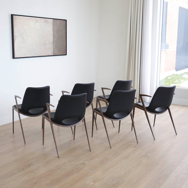 ensemble de chaises noires modernes avec accoudoirs en métal imitation bois et assise ajouree.