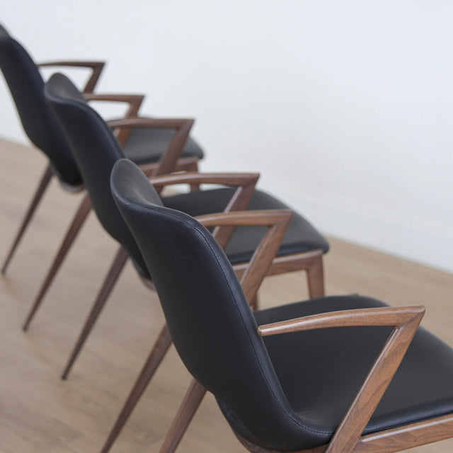 ensemble de chaises noires modernes avec accoudoirs en métal imitation bois et assise ajouree.