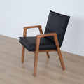 Chaise noire avec assise rembourree et structure en bois naturel.