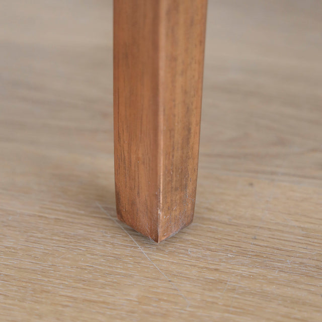 image rapprochée chaise noire avec assise rembourree et structure en bois naturel.