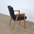 Chaise noire avec assise rembourree et structure en bois naturel.