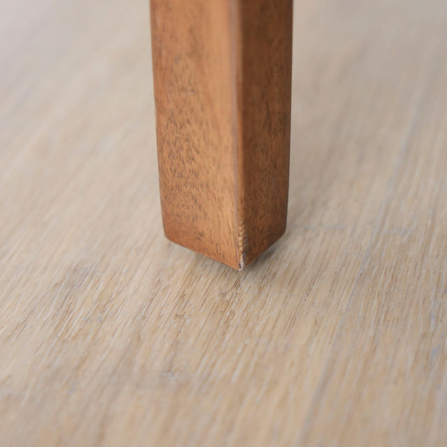 image rapprochée chaise noire avec assise rembourree et structure en bois naturel.