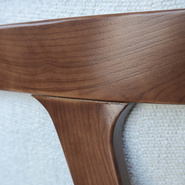 Fauteuil moderne en tissu bouclé ivoire avec structure en bois, idéal pour salon contemporain lumineux.