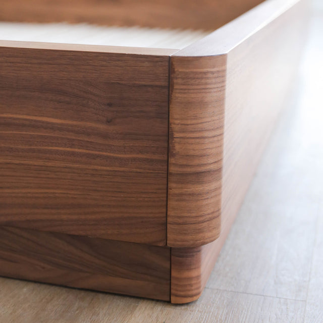 Lit en bois massif noyer avec tête de lit pleine, design minimaliste pour chambre moderne.