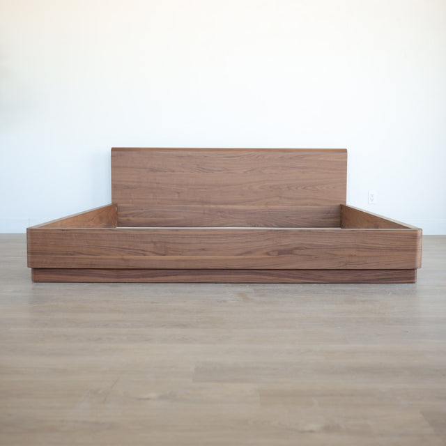 Lit en bois massif noyer avec tête de lit pleine, design minimaliste pour chambre moderne.