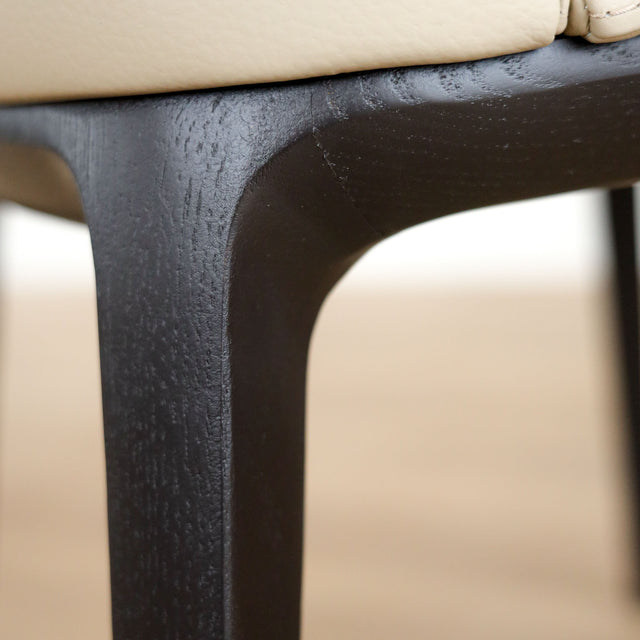 Chaise de salle à manger en cuir taupe avec pattes en noyer, design moderne pour intérieur contemporain.