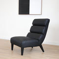 Fauteuil  en cuir végane noir avec dossier matelassé et pieds inclinés, style moderne pour salon. 